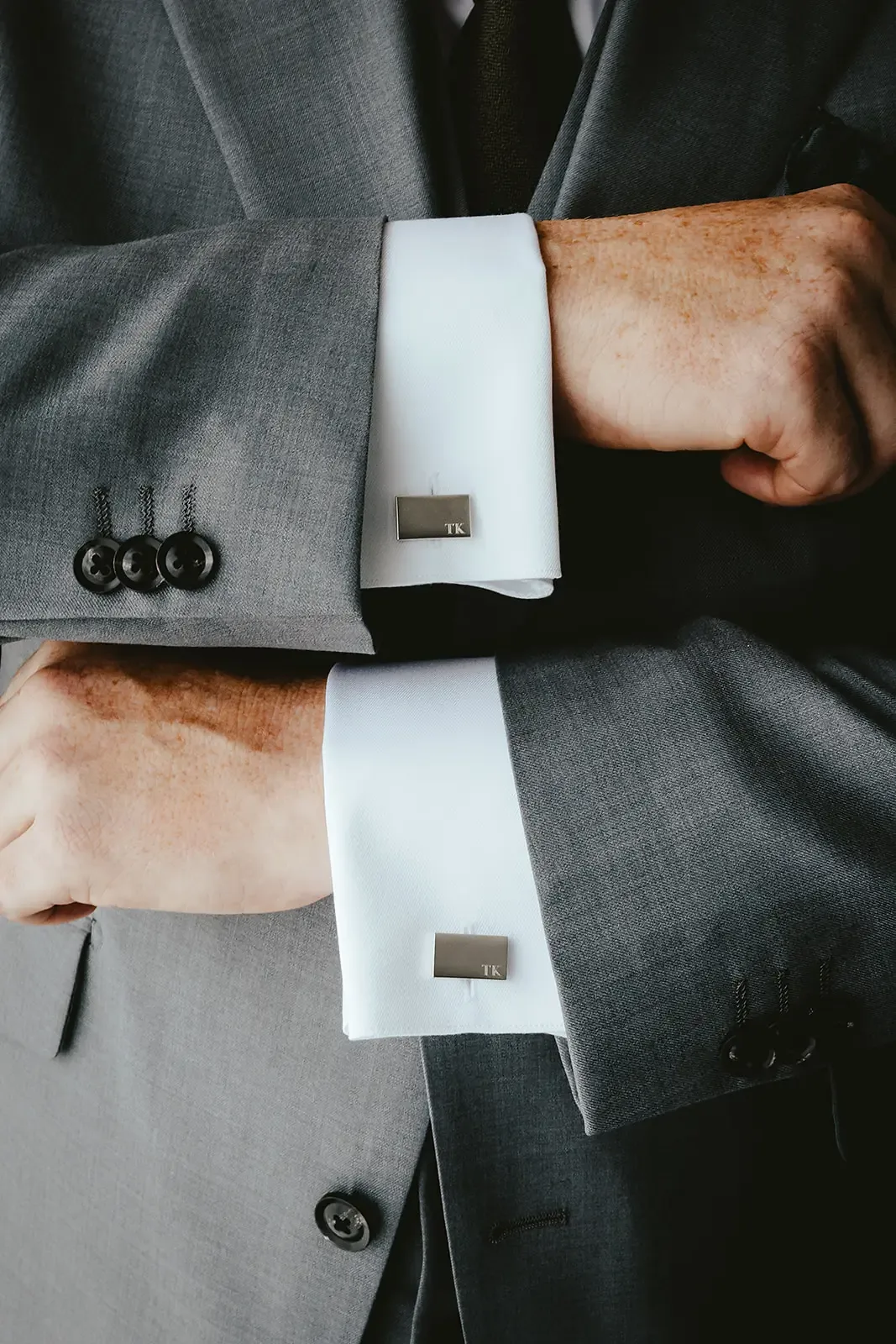 Monogrammed cufflinks on a groom's suit