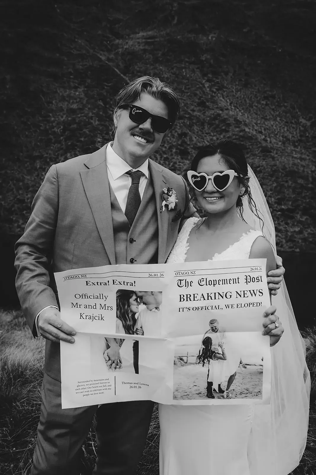 Couple holding a printed newspaper keepsake, black and white