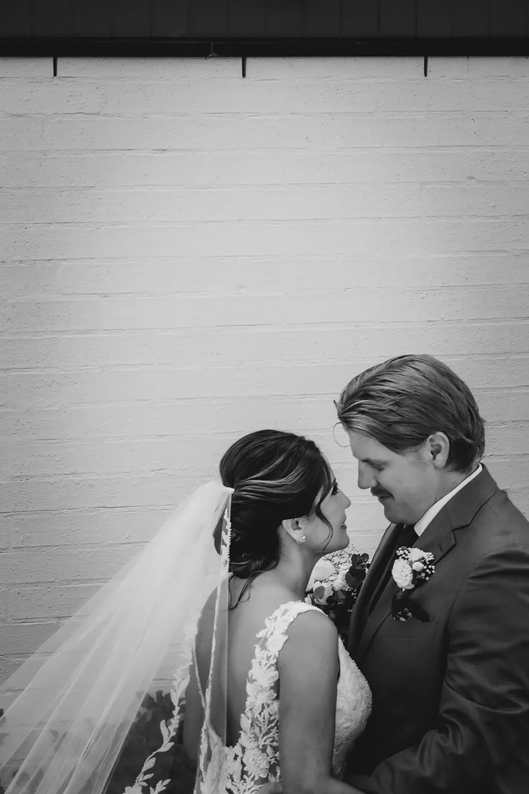 Bride and groom with foreheads touching, black and white