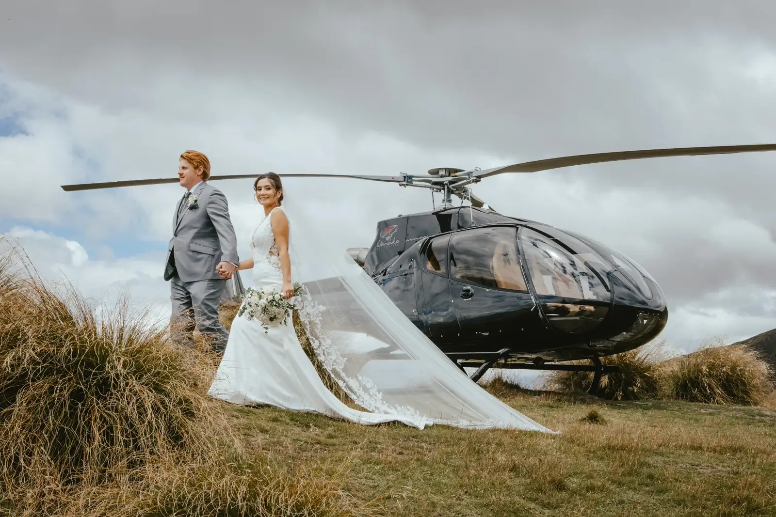 Couple walking away from the helicopter at Coromandel Peak