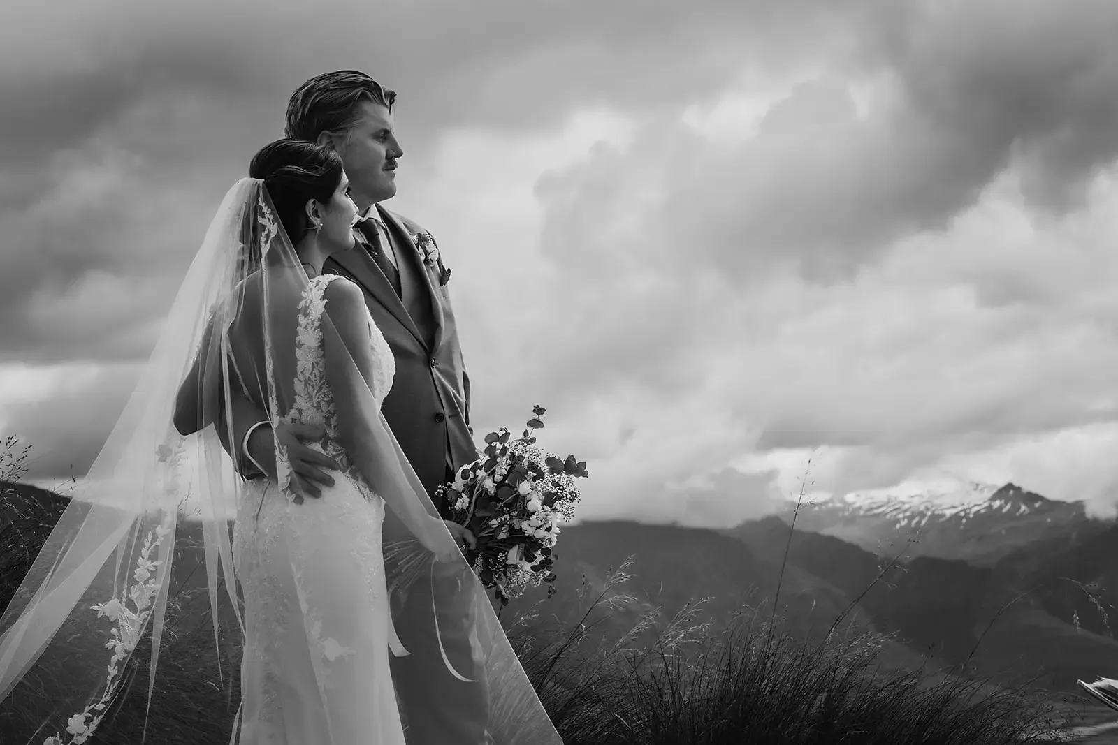 Black and white portrait of the couple with bouquet and veil