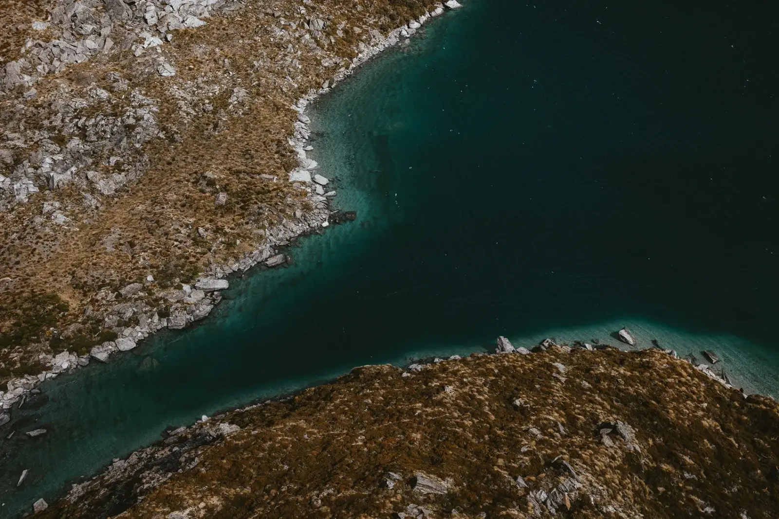 Teal water of the alpine lake at Lochnagar from the air