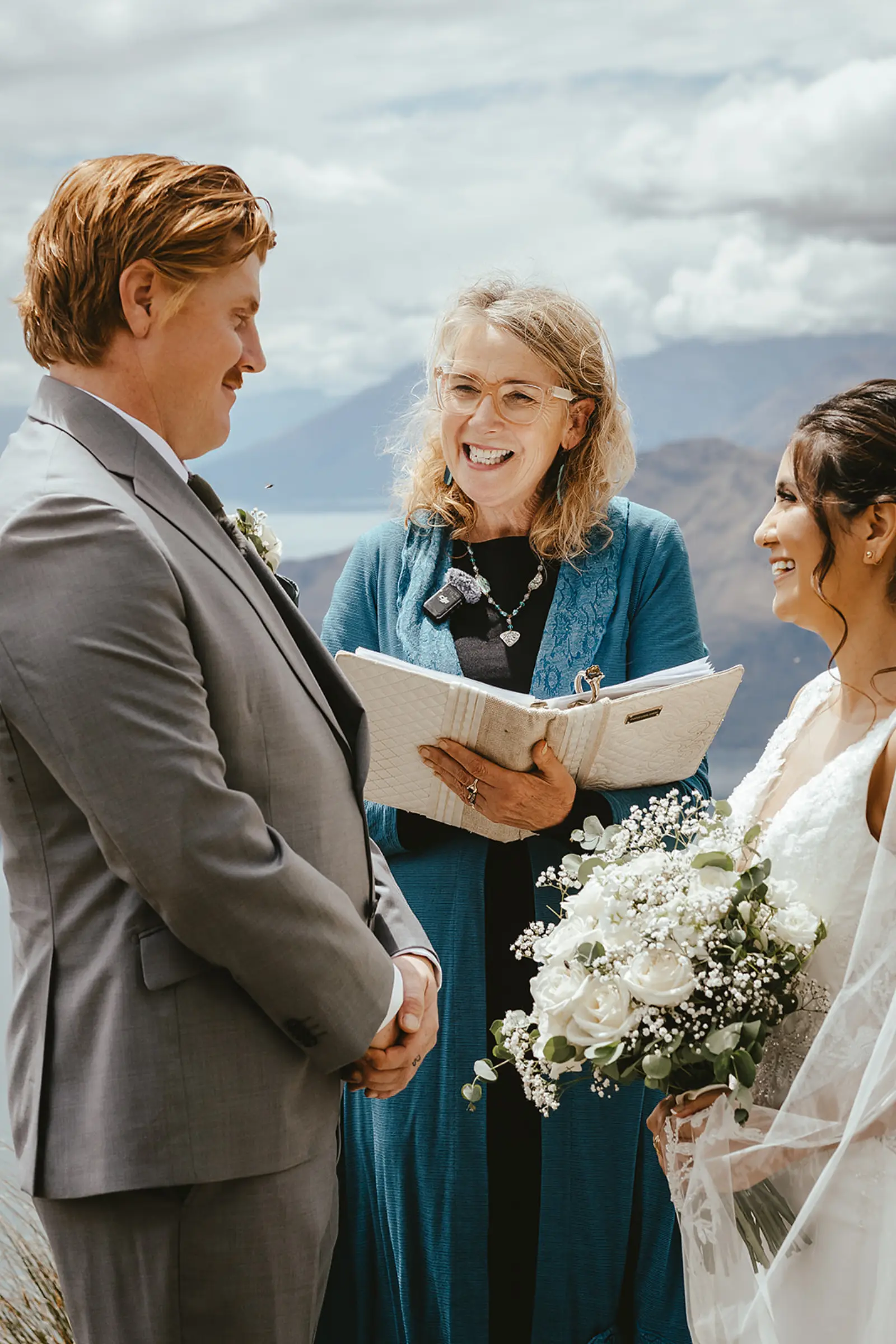 Couple exchanging vows with their celebrant on Coromandel Peak overlooking Lake Wānaka