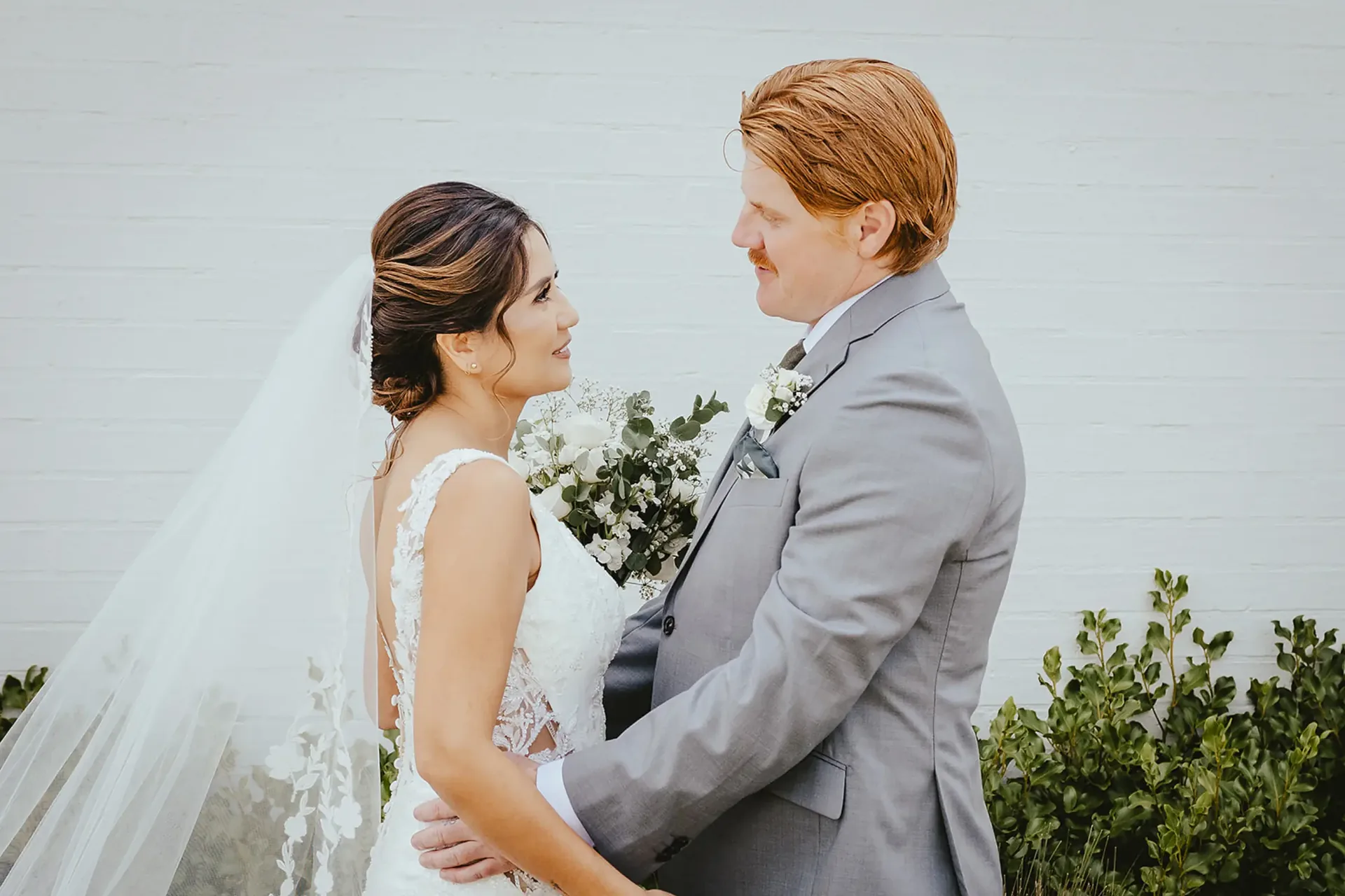 Bride and groom embracing at their first look, bride holding her bouquet