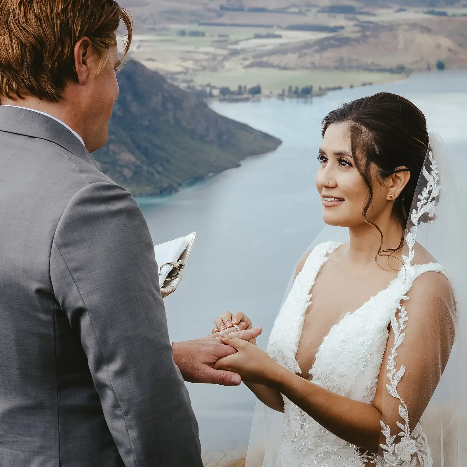 Bride during the vows with the lake view behind her
