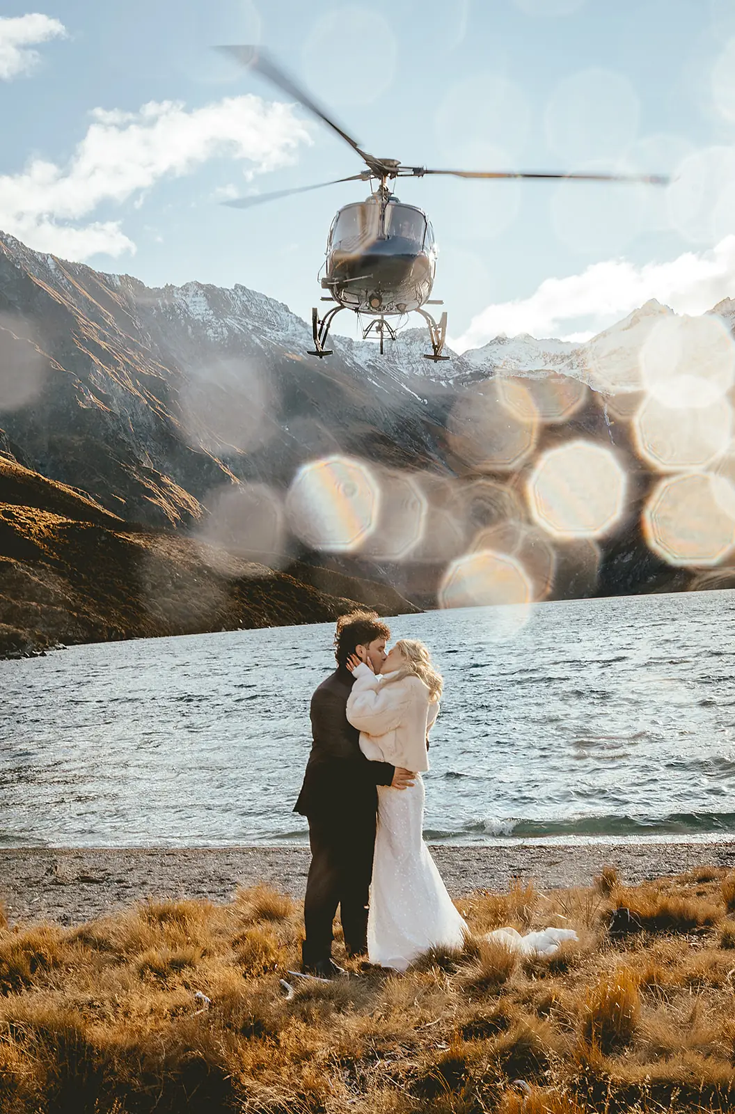 Couple kissing as the helicopter flies by the alpine lake at Lochnagar
