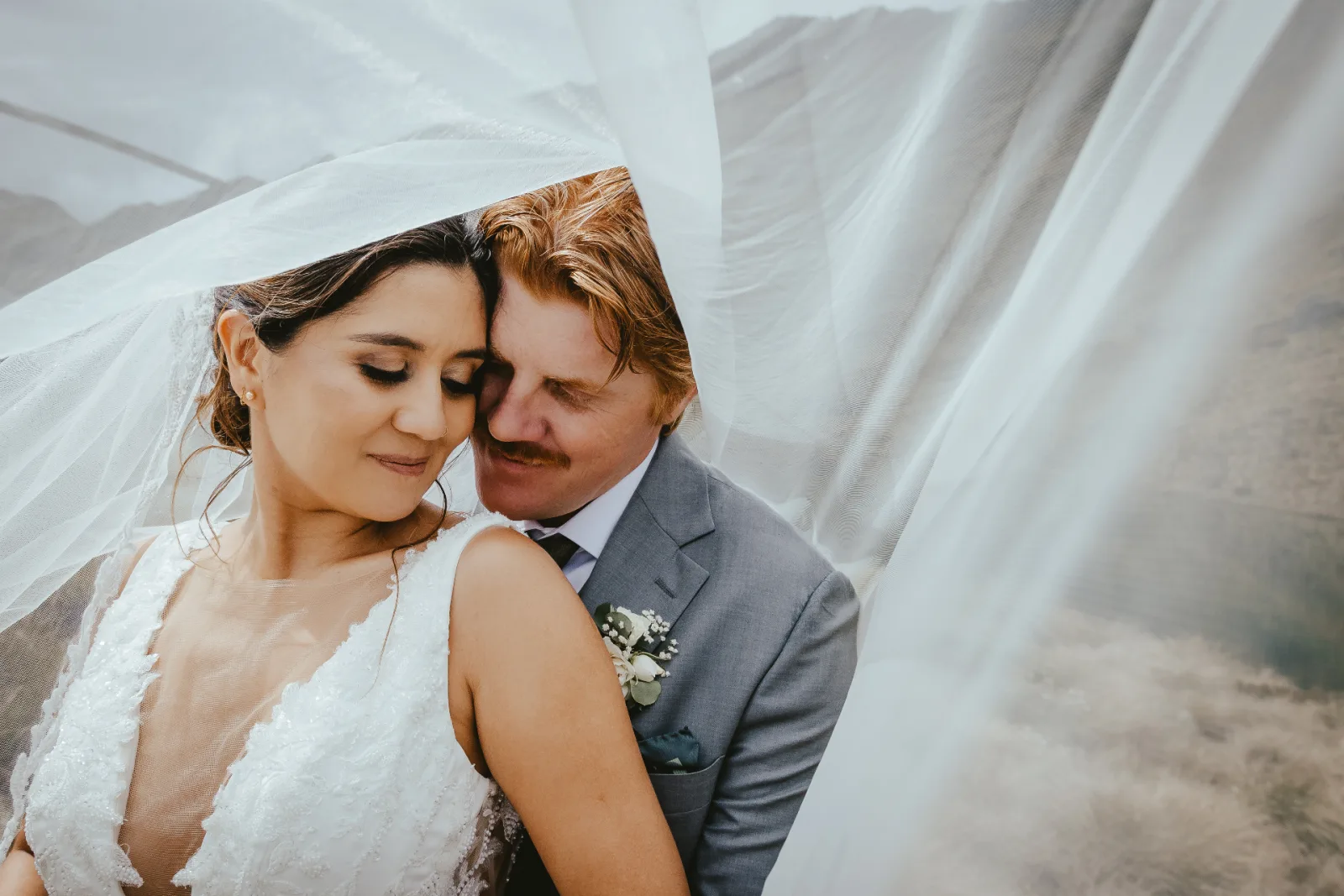 Close portrait of a couple under the bride's veil at Alta Lakes near Wānaka