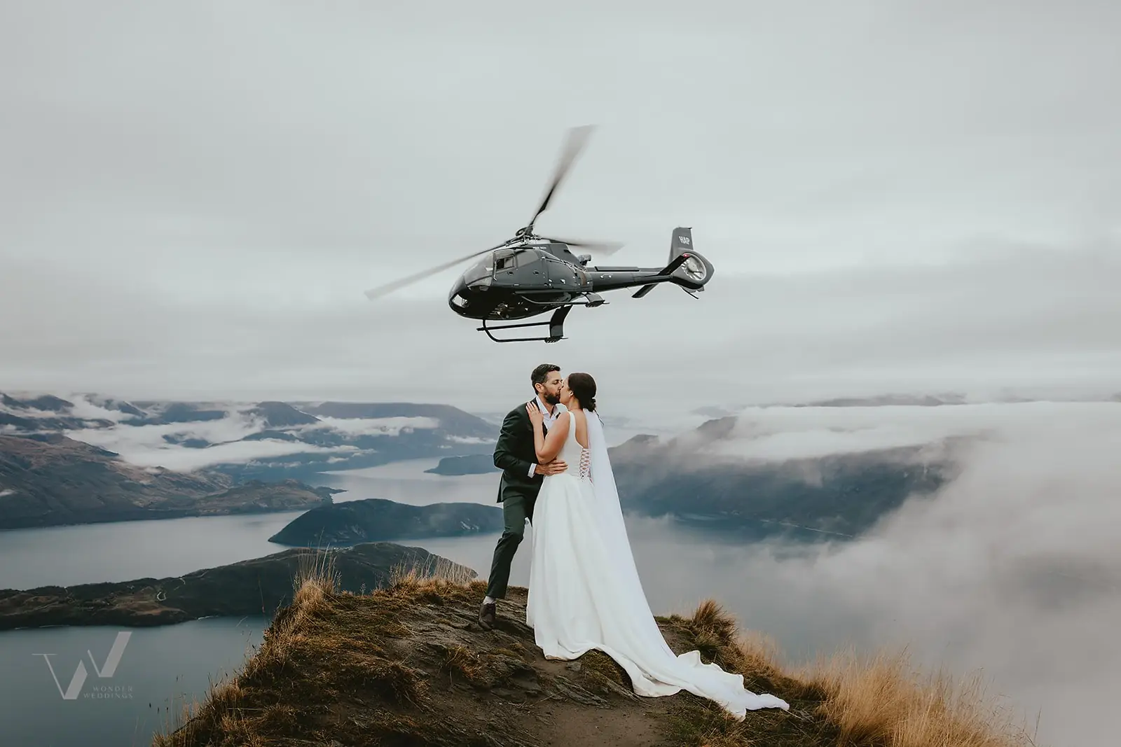 Couple kissing on Coromandel Peak above Lake Wānaka with cloud below