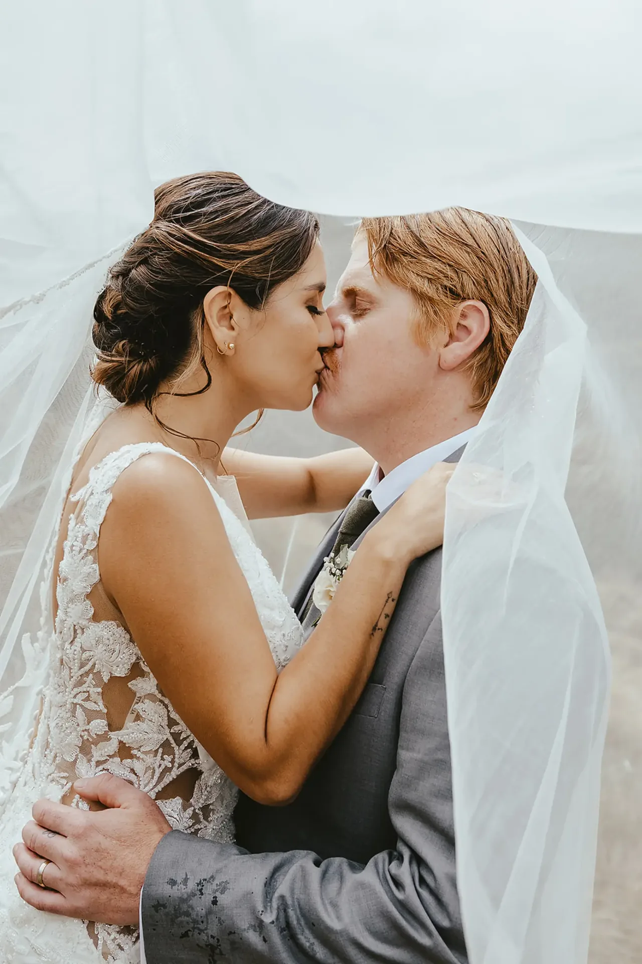 Couple kissing under the bride's veil