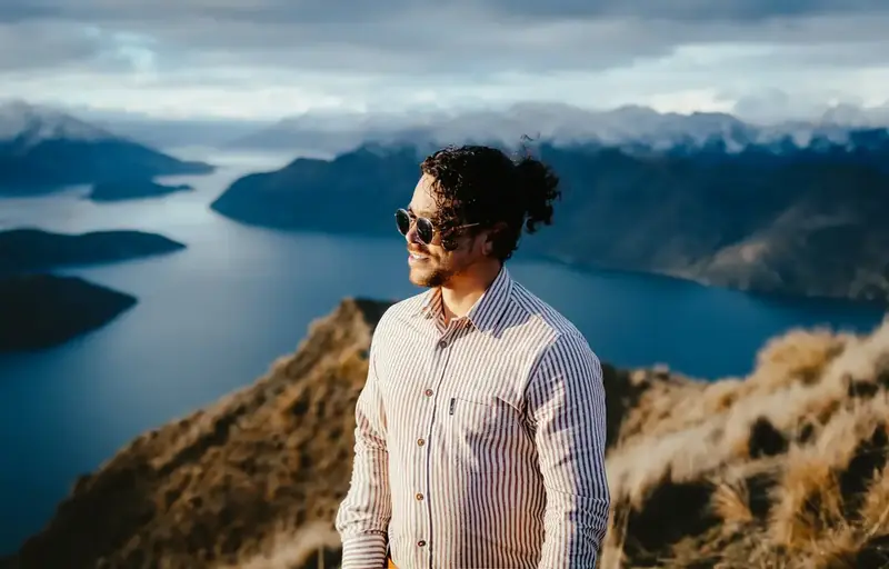 Cristian Batista standing on a mountaintop overlooking a lake