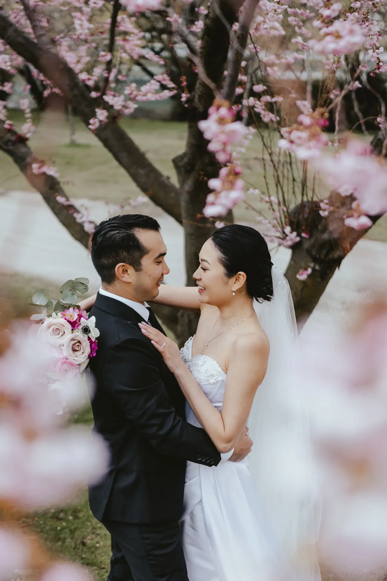 Couple embracing among spring blossom near Wānaka