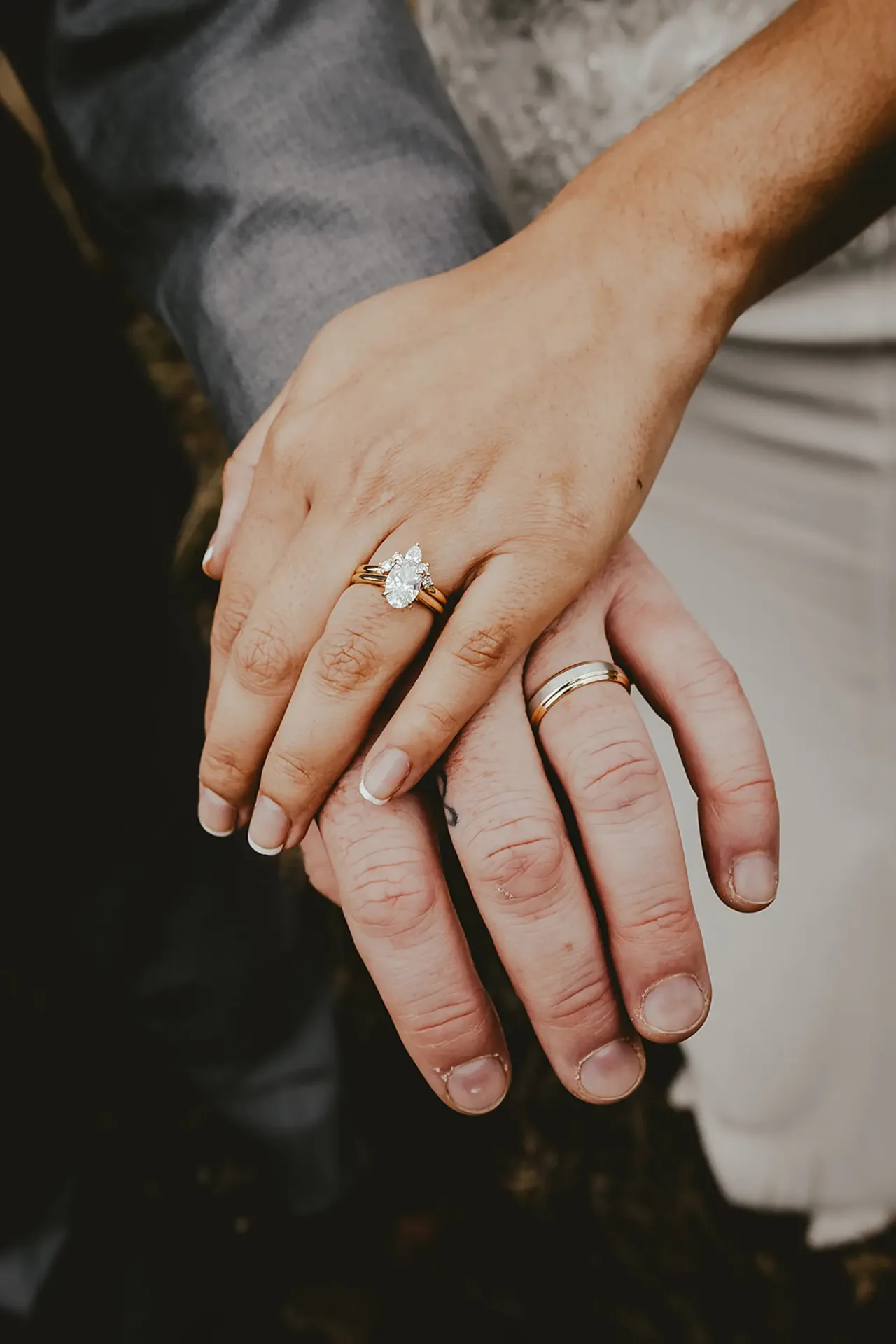 Close detail of the couple's hands with a pear diamond wedding ring